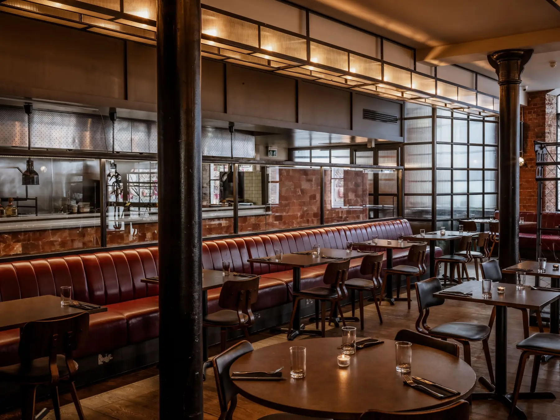 The Warehouse — long red leather banquette, open kitchen, cast-iron columns and warehouse windows