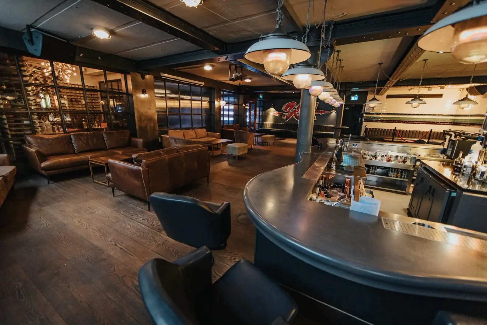 SIXT33N — leather sofas, a curved zinc bar and low pendant lights
