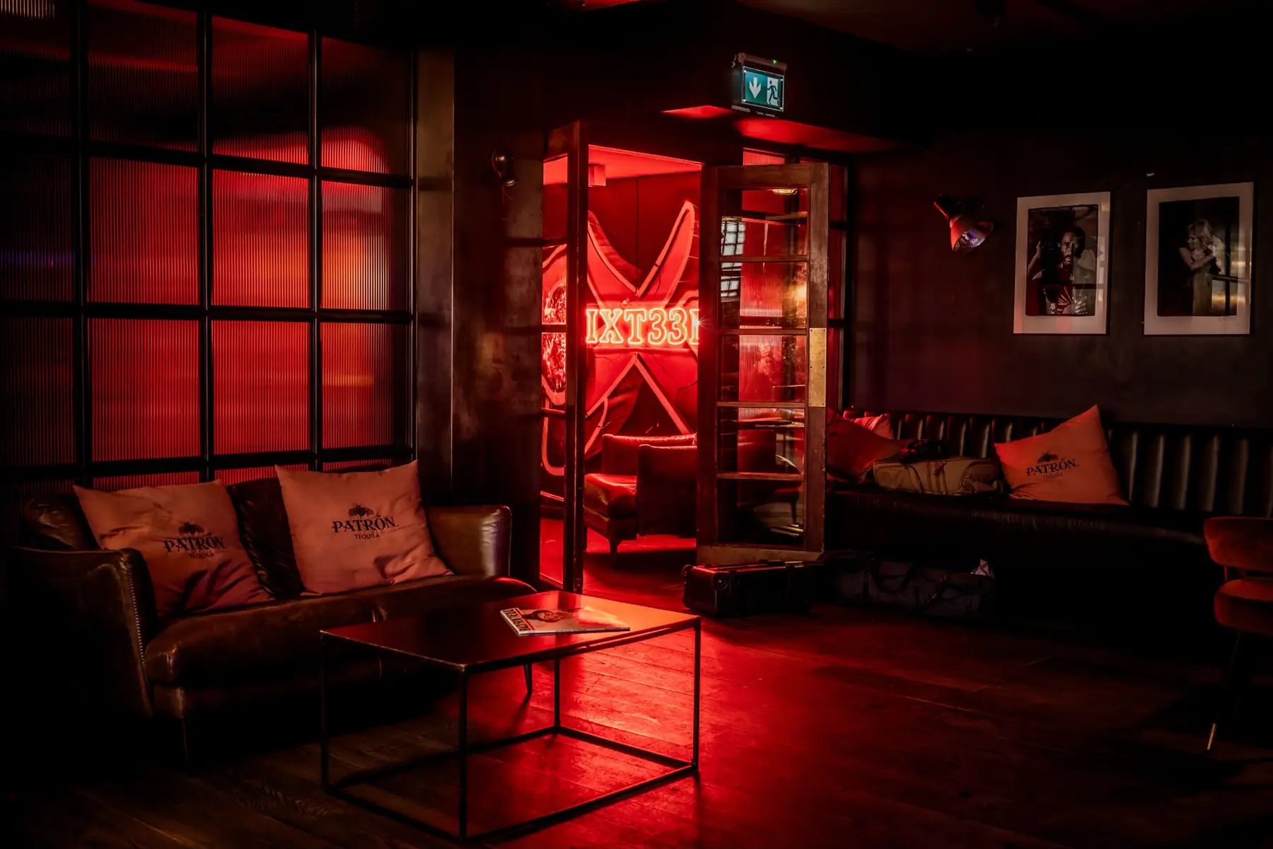 The red neon SIXT33N room behind the glass doors