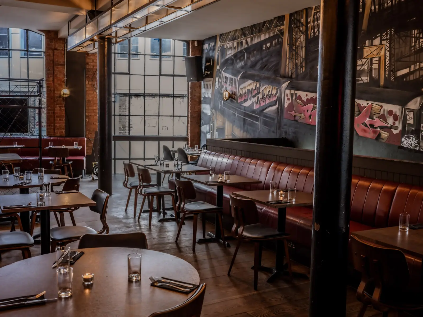 The Warehouse — the main room with graffiti mural, red banquettes and cast-iron columns